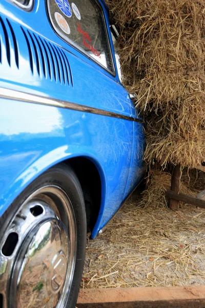 Parte azul vintage coche con una pila de paja . —  Fotos de Stock