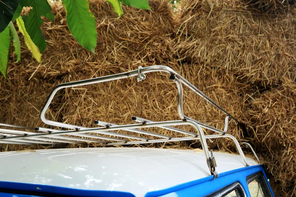 Part blue vintage car with a pile of straw. — Stock Photo, Image