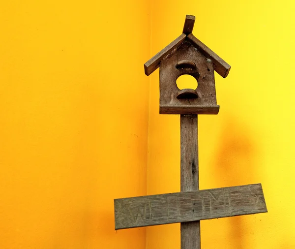 Wooden bird house with yellow wall — Stock Photo, Image