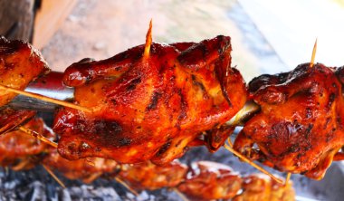 Çelik tak dönen bir ızgara üzerinde tüm ızgara tavuk.