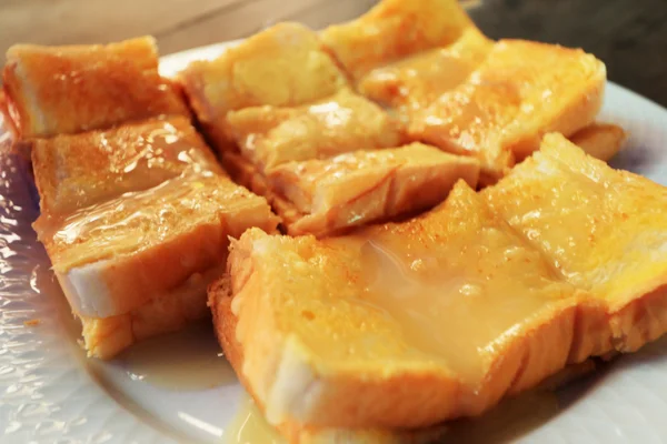 Brood en boter, gegarneerd met gezoete gecondenseerde melk — Stockfoto