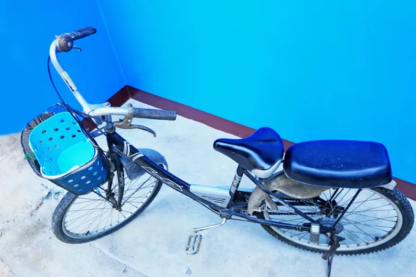 Bicicleta vieja estacionada solo una con paredes azules —  Fotos de Stock