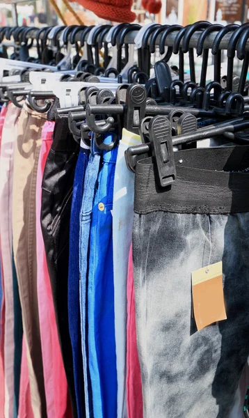 Shop pants hanging on a rack market. — Stock Photo, Image