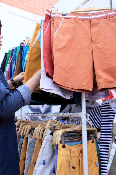 Shop pants hanging on a rack market. — Stock Photo, Image