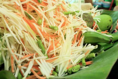 muz yaprağı üzerinde papaya salatası malzemeler