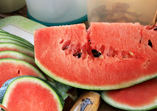 Melancia frutas fatiadas pedaços no chão de madeira . — Fotografia de Stock