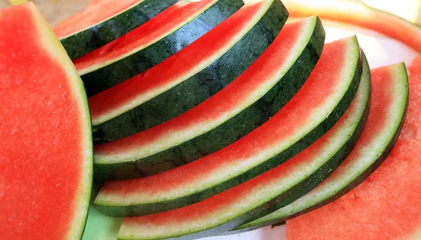 Melancia frutas fatiadas pedaços no chão de madeira . — Fotografia de Stock