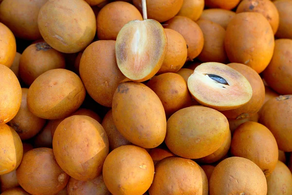 Sapodilla hromádku ovoce v pozadí — Stock fotografie