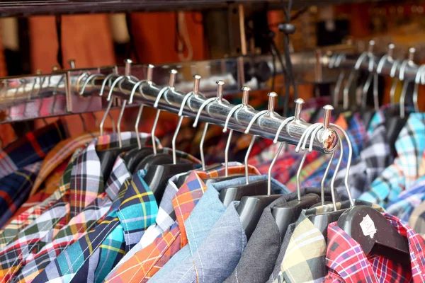 Shop shirts colorful fabric hanging on a rack. — Stock Photo, Image