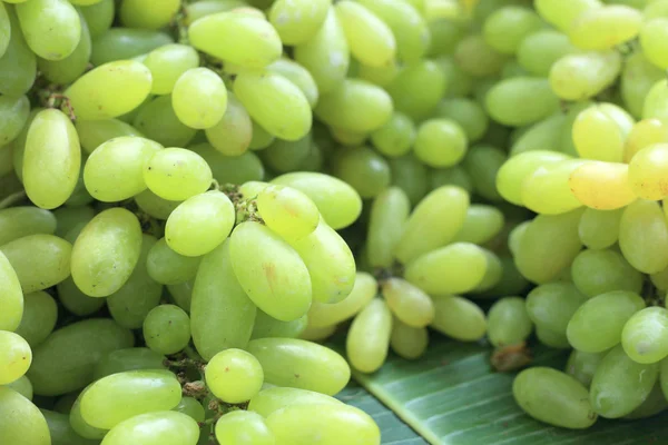 Uvas frescas sobre hojas de plátano verde — Foto de Stock