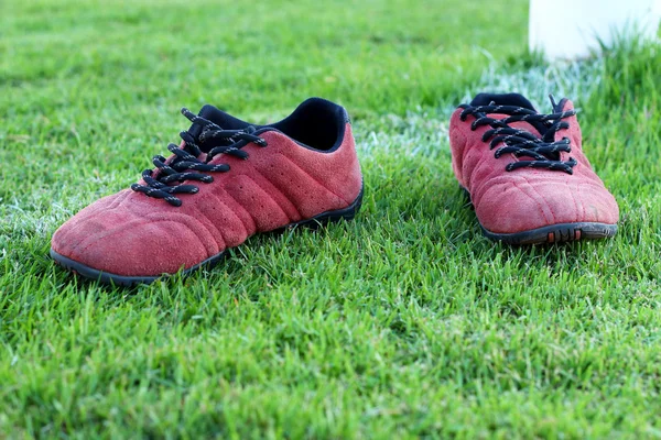 Sepatu merah rumput hijau di stadion . — Stok Foto