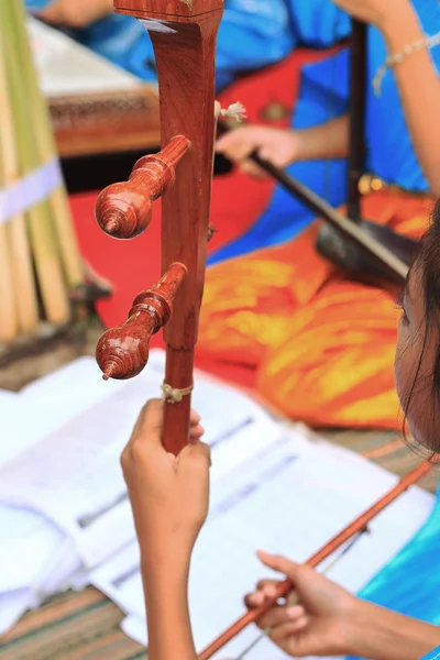 Uma menina toca um instrumento de música tailandesa local . — Fotografia de Stock