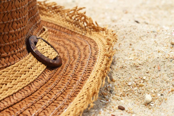 Close up van stro hoeden op het zand — Stockfoto