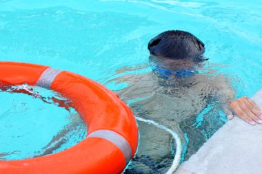 genç çocuk hayat yüzüğü havuzda