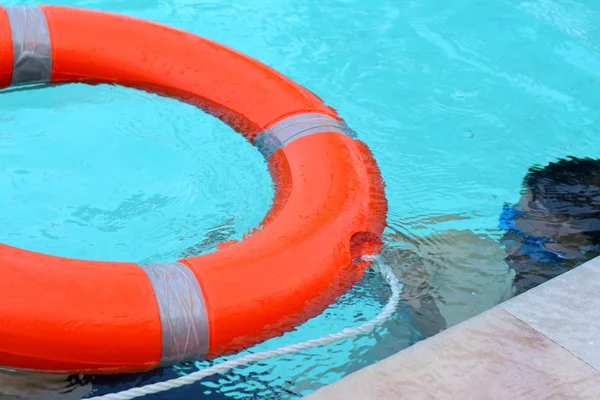 Ung pojke simning i poolen bär livet ring — Stockfoto