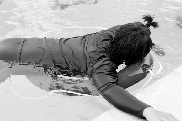 Menina nadando na piscina usando anel de vida — Fotografia de Stock