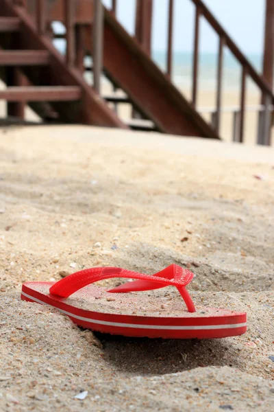 Rote Gummi-Flip-Flops im Sand — Stockfoto