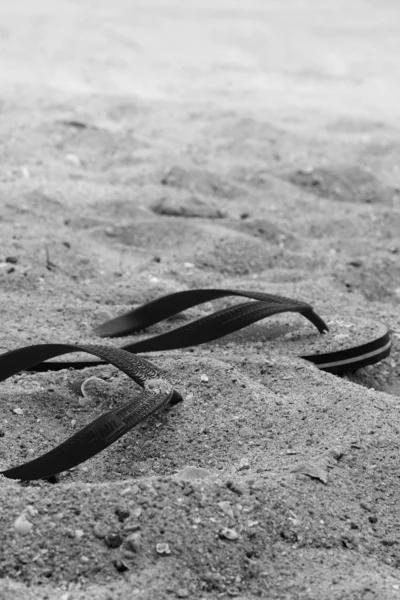 Rode rubberen slippers op het zand — Stockfoto