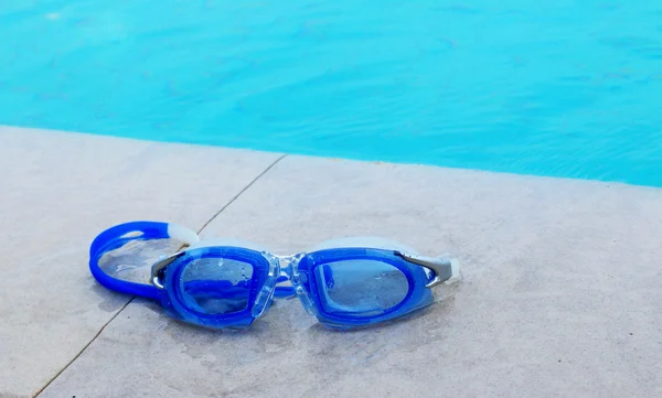 Occhiali da nuoto accanto alla piscina . — Foto Stock