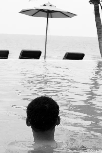 Jonge jongen zwemmen in het zwembad. — Stockfoto