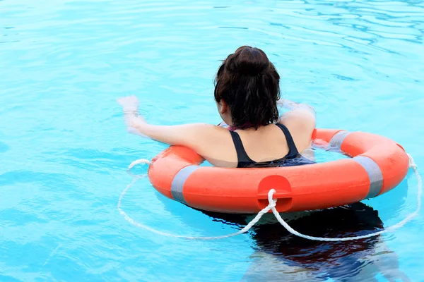 Tyttö uima-altaassa yllään elämän rengas — kuvapankkivalokuva