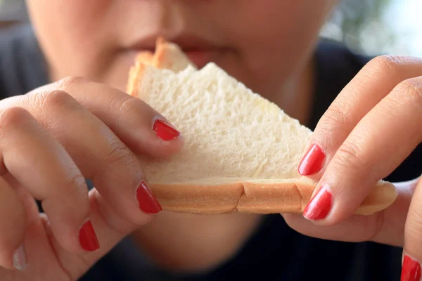 Woman eating sandwich bread.