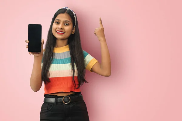 Heyecanlı genç Hintli Asyalı kız cep telefonunu tutuyor ve parmağıyla işaret ediyor, kopya alanı ile izole edilmiş dahiyane çözümler yaratıyor.