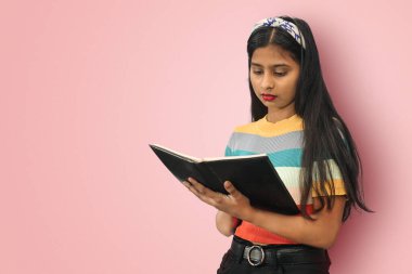 Genç, şirin, Asyalı bir kızın portresi. Olumlu duyguları ifade eden, izole edilmiş kitap pozları veriyor. Eğitim konsepti. Kopyalama alanı oluştur