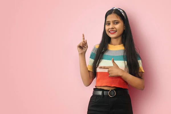 Smillig Hintli Asyalı genç kızın ayrı bir portresi uzayı kopyalamak için işaret ediyor, seçenekleri sunuyor, karar veriyor.