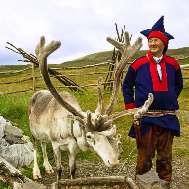 Honningsvag, Norveç - 30 Haziran 2022: Geyik ve ren geyiği yetiştiricisi ulusal kıyafetler giymişti. Sami, Kuzey Kutbu 'nda yaşayan insanlardır.