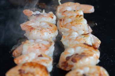 Siyah kızartma tavasında karides ızgarası, deniz yemeği.