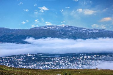 Norveç: Kuzey Kutup Dairesi ötesindeki Tromso Norveç kasabası, mavi gökyüzü ile dağ manzarası