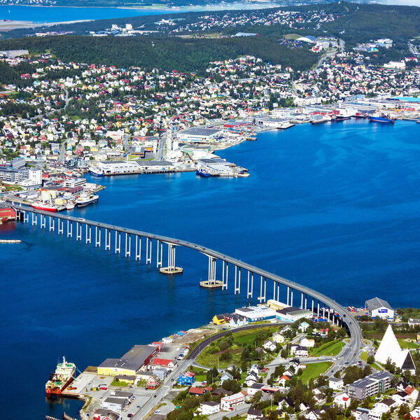 Тромсо - дома, мост и панорама норвежского города Тромсо за полярным кругом с гор в норвежских фьордах.