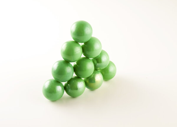 triangle of green marbles on a white background