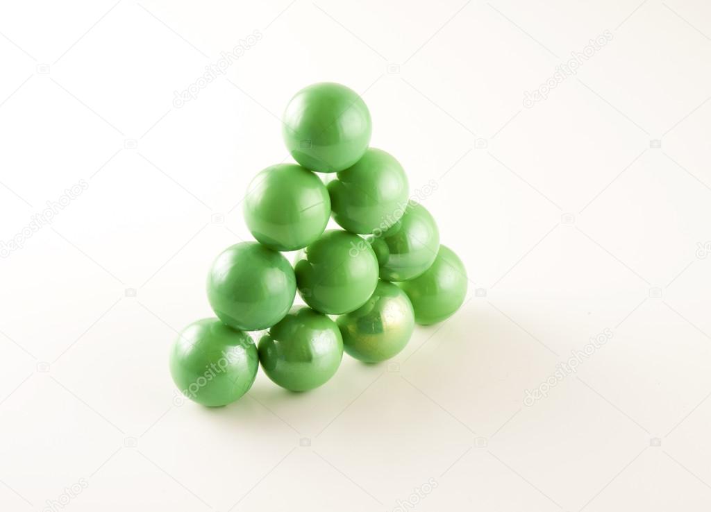 triangle of green marbles on a white background