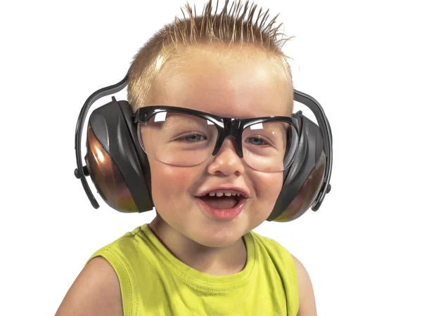Niño sentado con auriculares en la cabeza sobre un fondo blanco Fotos de stock libres de derechos