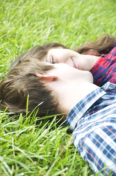 Jovem casal deitado na grama — Fotografia de Stock