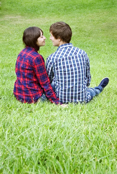 Jovem casal sentado na grama — Fotografia de Stock