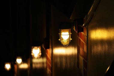 Bodruma inen merdivenleri aydınlatan duvarda gemi ışıkları vardı.
