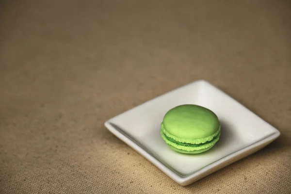 Still life of a macaron food model on a white plate