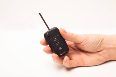 Arabanın anahtarını elinde beyaz arka plan üzerinde izole