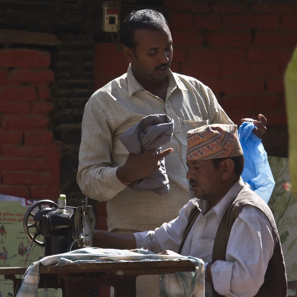 Tailor man, doing retouch for a customer, is working in outdoor — Stock Photo, Image