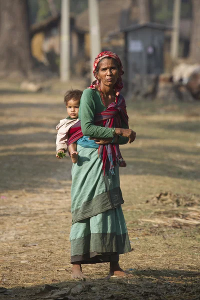 若い男の子を運ぶ歳のネパール人女性 — ストック写真