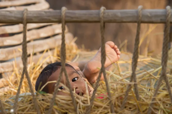 Anak nepali muda bermain di keranjang jerami di Nepal — Stok Foto