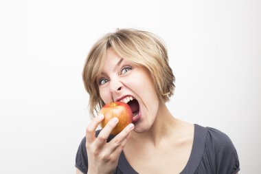 young woman eating apple on white background