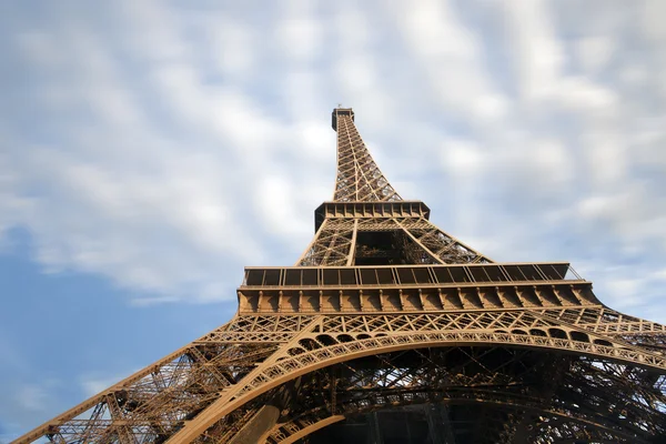 Detalle de la torre Eiffel con nubes en movimiento en el cielo azul, París — Foto de Stock