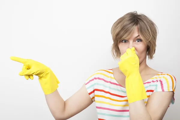 Young beautiful woman in rubber gloves holding her nose — Stock Photo, Image