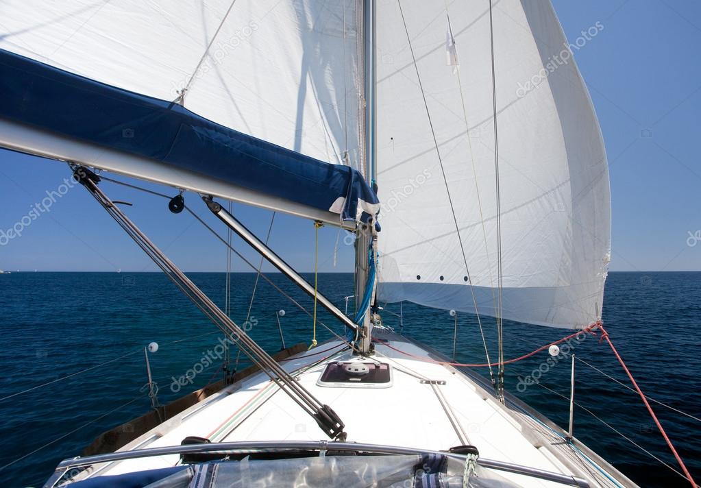 Sailing yacht on back wind on blue sea and blue sky
