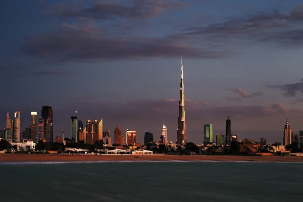 Dubai skyline al atardecer visto desde la costa del Golfo — Foto de Stock