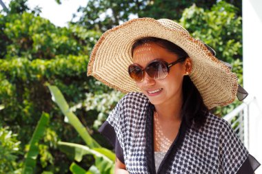 şapka ve güneş gözlüğü bir Balkonda duran genç kadın